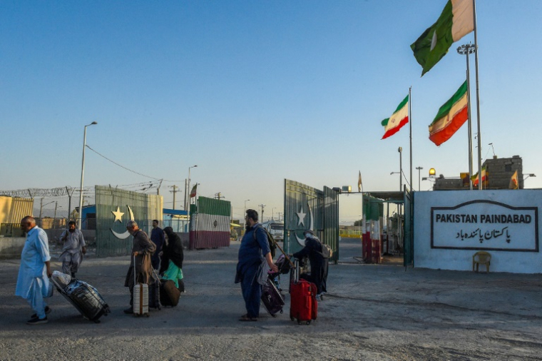 Des pèlerins pakistanais évacués traversent la frontière fermée pour fuir le conflit israélo-iranien le 18 juin 2025 à Taftan (Baloutchistan) ( AFP / Banaras KHAN )