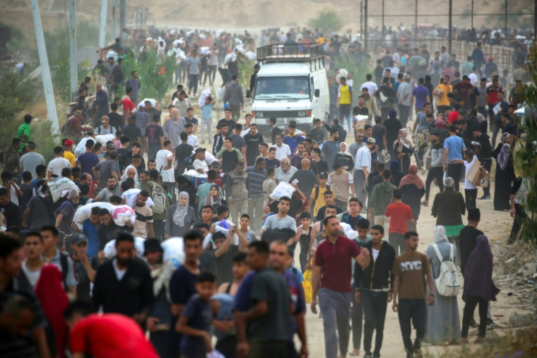 Des Palestiniens déplacés transportent des fournitures de secours distribuées par la Fondation humanitaire de Gaza (GHF), soutenue par les États-Unis, dans le centre de la bande de Gaza, le 8 juin 2025 ( AFP / Eyad BABA )