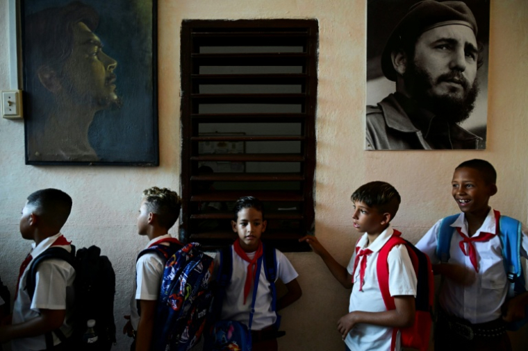 Des élèves sont en rang sous les portraits des dirigeants de la révolution cubain, Fidel Castro et l'Argentin Che Guevara, le jours de la rentrée des classes dans une école de La Havane, le 1er septembre 2026 ( AFP / YAMIL LAGE )