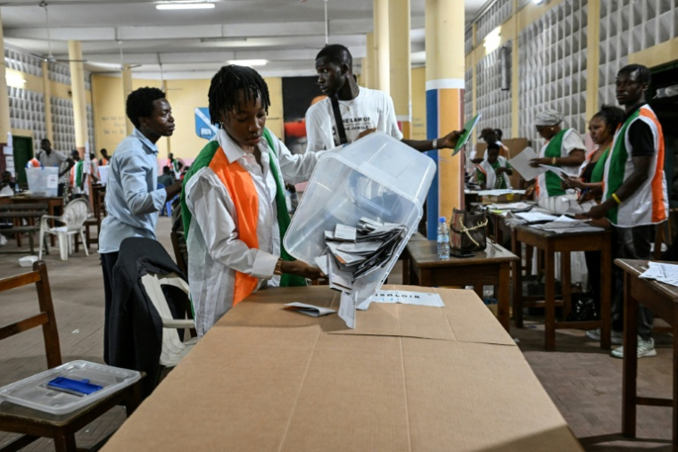 Une représentante de la commission électorale vide une urne pour le dépouillement des votes de la présidentielle ivoirienne, le 25 octobre 2025 à Abidjan ( AFP / Sia KAMBOU )