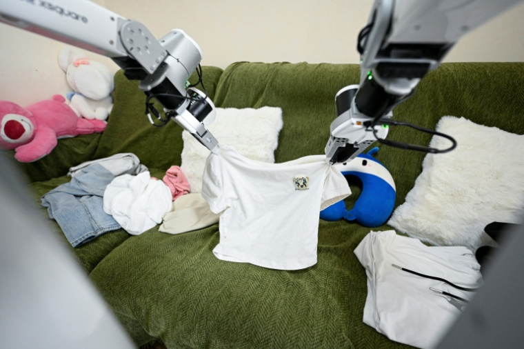 Un robot de ménage X Square plie des vêtements au domicile d'une cliente, le 21 mai 2026 à Pékin, en Chine ( AFP / WANG Zhao )