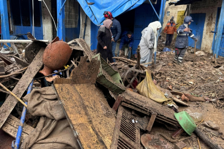 Des personnes marchent parmi les débris dans la zone du marché après une crue soudaine, dans la ville côtière de Safi, à environ 300 kilomètres au sud de la capitale Rabat, le 15 décembre 2025 ( AFP / - )
