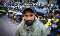 Le livreur de repas bangladais Sabbirrul Alam dans une rue de Bucarest, le 20 octobre 2025 en Roumanie ( AFP / Daniel MIHAILESCU )