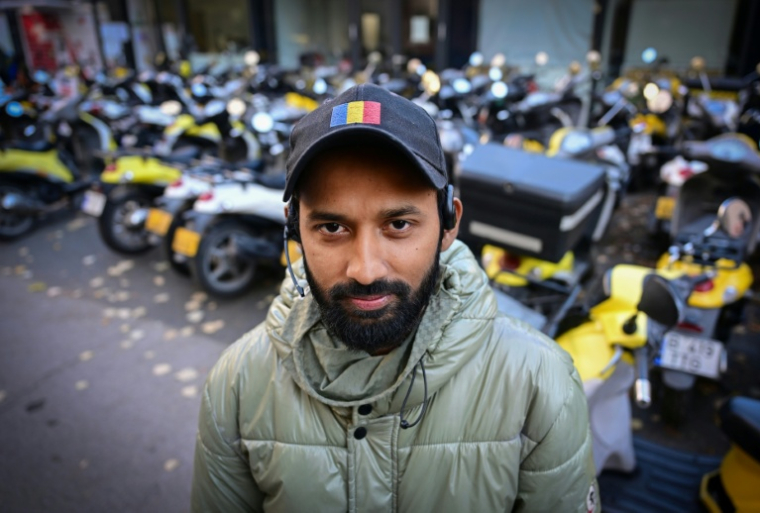 Le livreur de repas bangladais Sabbirrul Alam dans une rue de Bucarest, le 20 octobre 2025 en Roumanie ( AFP / Daniel MIHAILESCU )