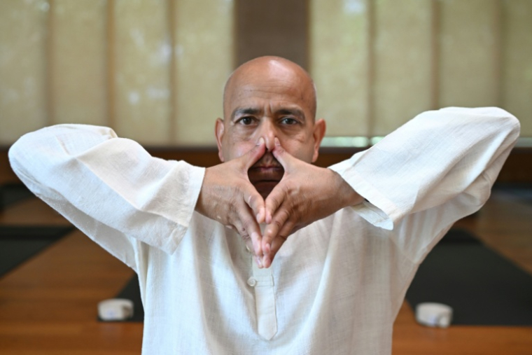 Varun Veer, fondateur de Lifeyoga, fait une démonstration de "Pranayama" lors d'une séance dans son studio de New Delhi, le 19 juin 2026 en Inde ( AFP / Arun SANKAR )