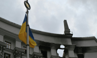 Un drapeau ukrainien flotte devant le bâtiment du gouvernement ukrainien endommagé la veille lors d'une frappe aérienne massive russe, le 8 septembre 2025 à Kiev  ( AFP / Genya SAVILOV )