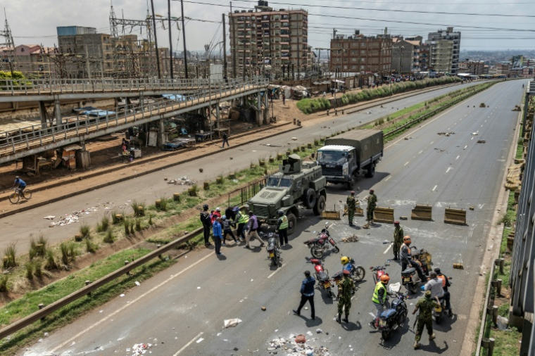 Des policiers kényans dégagent des barricades pour rétablir la circulation sur une voie rapide de Nairobi, le 18 mai 2026, jour de grève des transports et de protestation contre une nouvelle hausse des prix des carburants au Kenya ( AFP / Luis TATO )