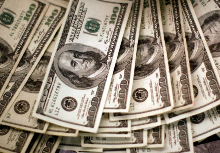 Des dollars américains sont comptés à un comptoir