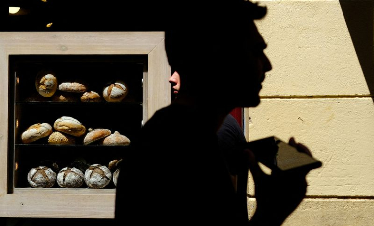 Des gens passent devant une boulangerie, à Barcelone, Espagne