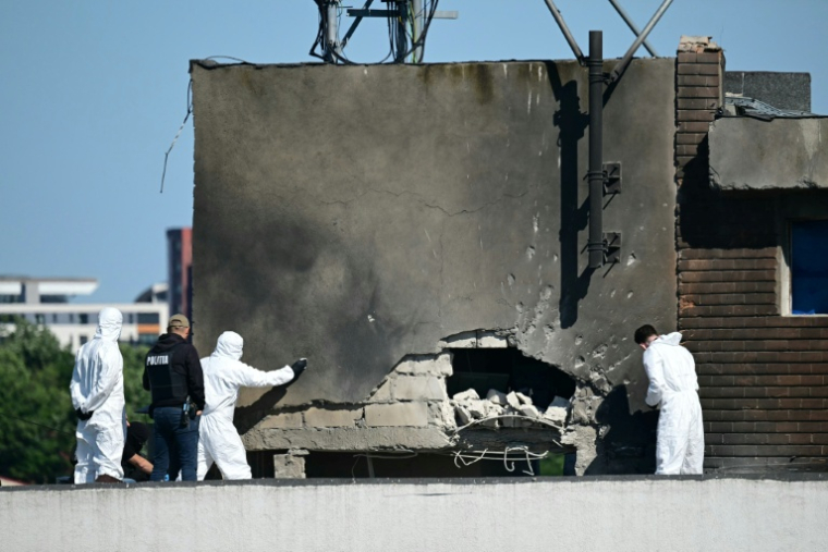 Des policiers et enquêteurs sur le lieu d'impact après qu'un drone russe a percuté un immeuble d'habitation à Galati, le 29 mai 2026 dans l'est de la Roumanie ( AFP / Daniel MIHAILESCU )