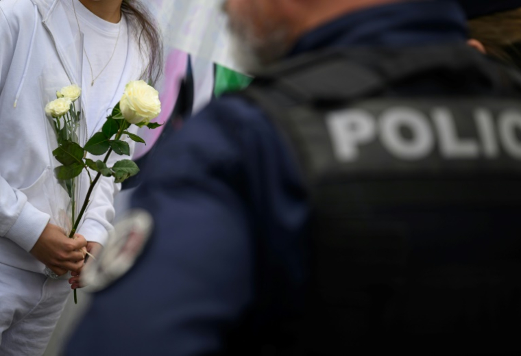 Une élève apporte des fleurs à Nantes, le 25 avril 2025, au lendemain d'une attaque au couteau dans un établissement scolaire qui a fait un mort et trois blessés ( AFP / Loic VENANCE )