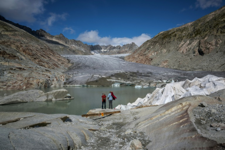 Des touristes devant le glacier du Rhône près de Gletsch, dans les Alpes suisses, le 12 septembre 2025 ( AFP / Fabrice COFFRINI )