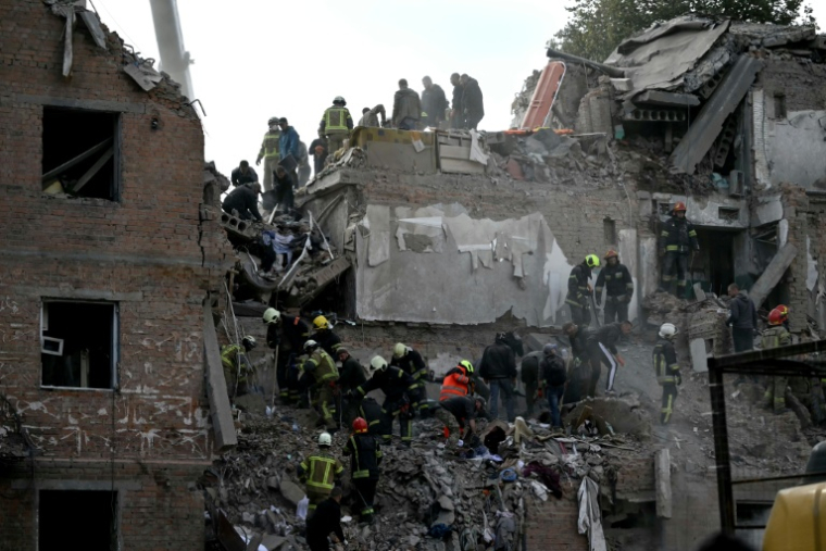 Des secouristes recherchent des survivants dans les décombres d'un immeuble résidentiel après une frappe aérienne russe à Prylouky, le 7 octobre 2026 dans le nord de l'Ukraine ( AFP / Genya SAVILOV )