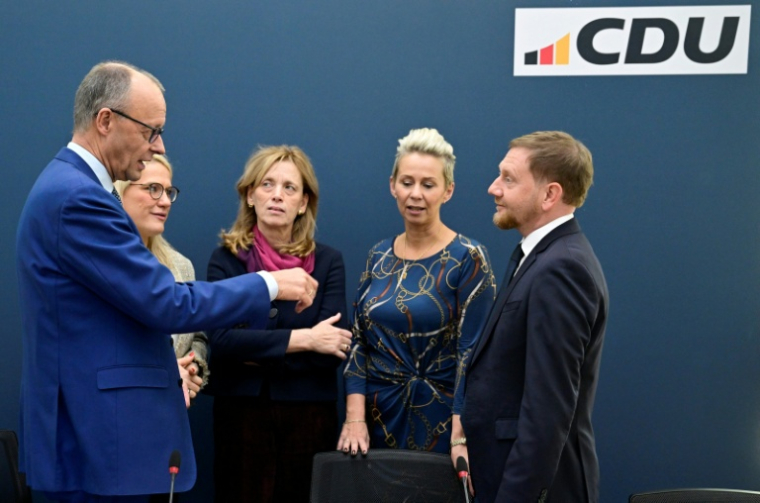 Le chancelier allemand Friedrich Merz discute avec des membres de son parti, la CDU, le 20 octobre 2025 à Berlin ( AFP / John MACDOUGALL )