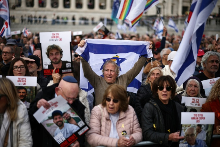 Des personnes tiennent des photos d'otages israéliens lors d'un événement commémoratif organisé par la communauté juive pour honorer les vies perdues lors de l'attaque du Hamas le 7 octobre 2023, à Londres, le 5 octobre 2025 ( AFP / HENRY NICHOLLS )
