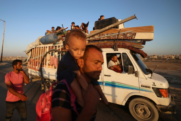 Des Palestiniens de la ville de Gaza se déplacent vers le sud de la bande de Gaza avec leurs affaires, sur la route côtière le long du camp de réfugiés de Nousseirat dans le centre du territoire, pour fuir une opération militaire israélienne, le 20 septembre 2025 ( AFP / Eyad BABA )