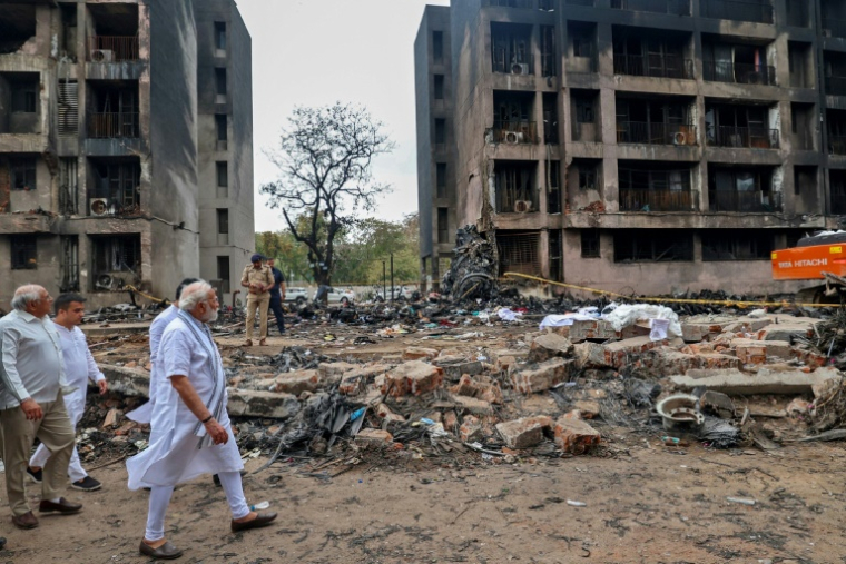 Photo prise et diffusée par le Bureau d'information de la presse indienne (PIB), le 13 juin 2025, du Premier ministre indien Narendra Modi sur le site du crash du vol 171 d'Air India dans un quartier résidentiel, près de l'aéroport d'Ahmedabad ( Indian Press Information Bureau (PIB) / - )