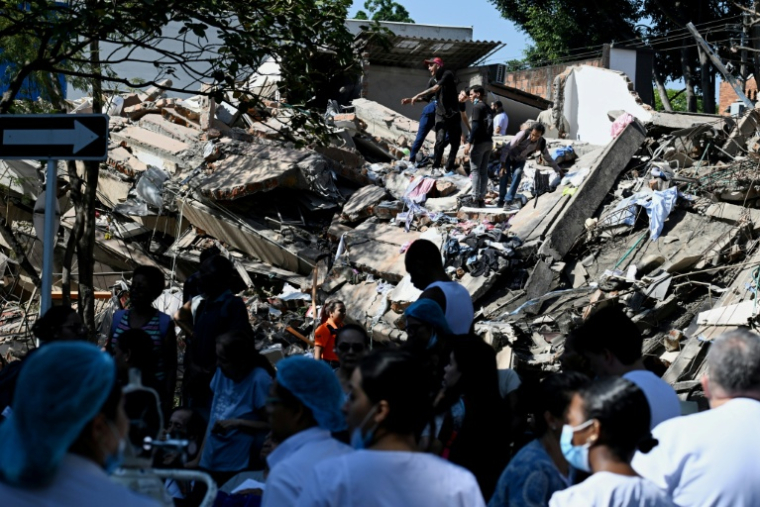 Des personnes sur un bâtiment effondré après un séisme à Cali, en Colombie, le 10 août 2026 ( AFP / Joaquin SARMIENTO )