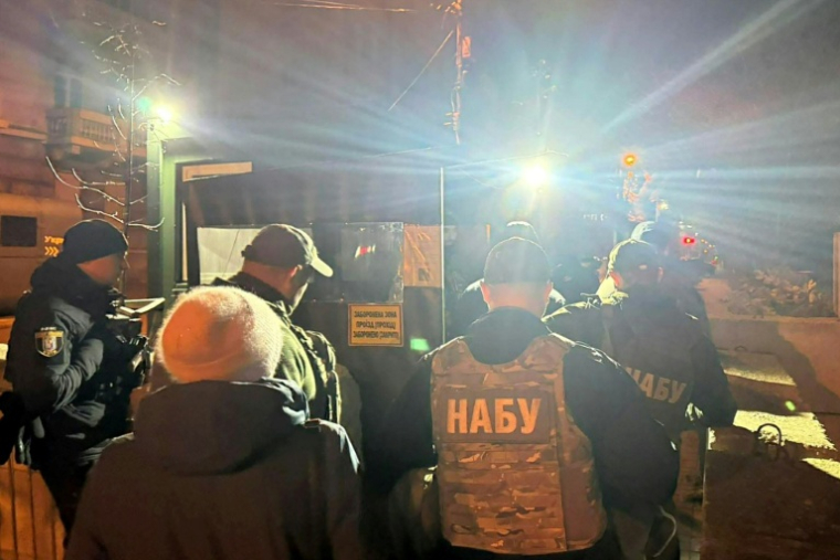 Sur cette photo prise et fournie à l'AFP par le média ukrainien "Ukrainska Pravda" le 28 novembre 2025, des agents de l'agence anticorruption ukrainienne (NABU) passent un poste de contrôle dans le quartier gouvernemental de Kiev ( Ukrainska Pravda / Handout )