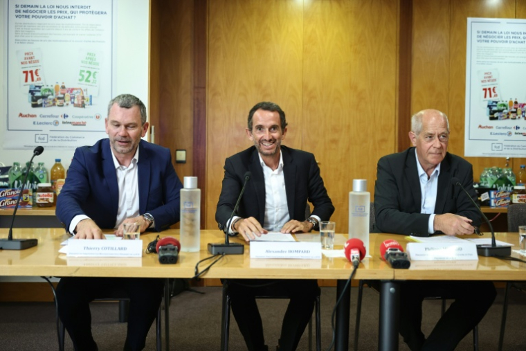 De gauche à droite, Thierry Cotillard, patron des Mousquetaires/Intermarché, Alexandre Bompard, patron de Carrefour, et Philippe Michaud, celui de l'enseigne E.Leclerc, à Paris le 22 juin 2026 ( AFP / Simon WOHLFAHRT )