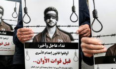 Des manifestants brandissent des pancartes sur lesquelles on peut lire "Appel urgent et final : arrêtez l'application de la loi sur les prisonniers avant qu'il ne soit trop tard" devant les locaux de la Croix-Rouge à Ramallah, en Cisjordanie occupée par Israël, le 31 mars 2026 ( AFP / Zain JAAFAR )