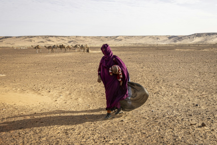 Une femme emmène son enfant à un poste d'infirmerie à Oued Chebi, en Mauritanie, le 6 avril 2025 ( AFP / PATRICK MEINHARDT )