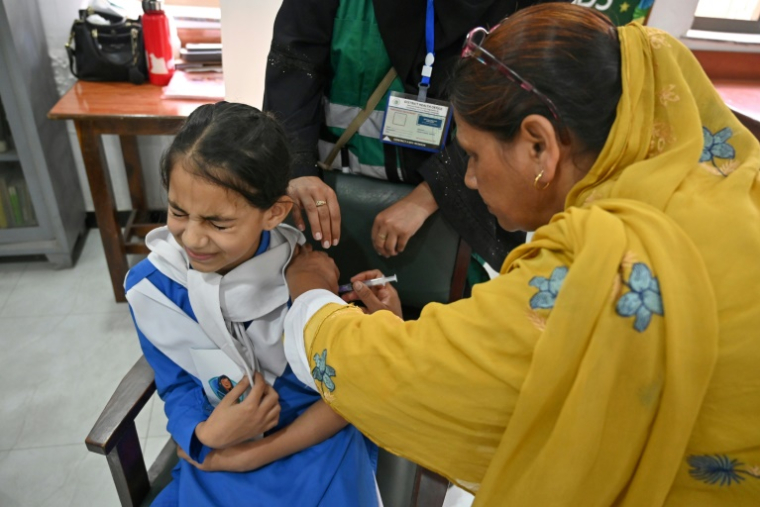 Une soignante (g) administre le vaccin contre le virus du papillome humain (VPH) à une adolescente, lors d'une campagne de vaccination contre le cancer du col de l'utérus, le 24 septembre 2025 à Islamabad, au Pakistan ( AFP / Farooq NAEEM )