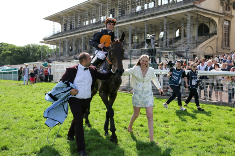 Le cheval "Gran Diose" monté par Clément Lefebvre (C), après sa victoire lors de la 146e édition du "Grand steeple-chase de Paris", avec son entraîneur Louisa Carberry (D) et son lad Jimmy Guilleux (G) le 19 mai 2024 à l'Hippodrome d'Auteuil, à Paris ( AFP / Thomas SAMSON )
