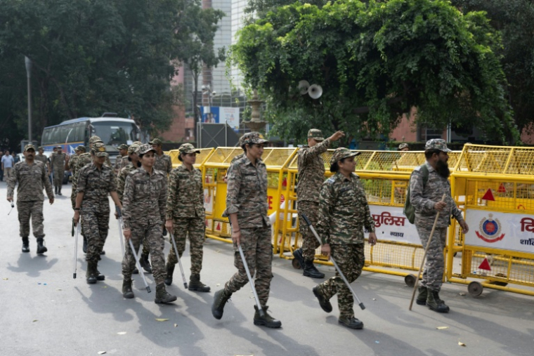 Les membres des forces de sécurité arrivent pour prendre leur poste à un point de contrôle temporaire à New Delhi, le 11 octobre 2026 ( AFP / Sajjad HUSSAIN )