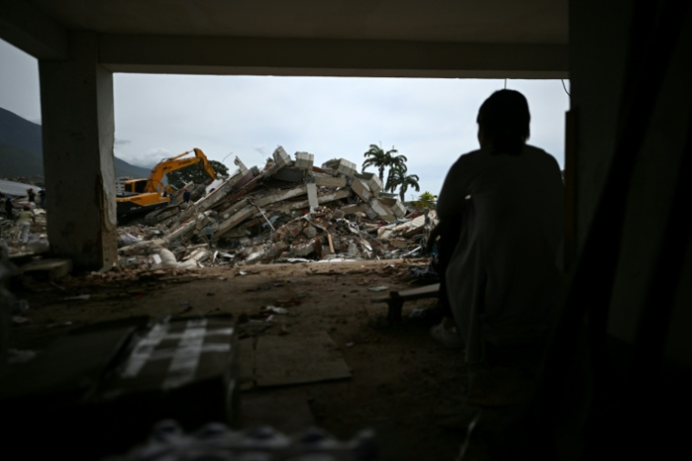 Une femme devant un immeuble effondré lors des séismes au Venezuela, à Caraballeda, dans l'Etat de La Guaira, le 30 juin 2026 ( AFP / Juan BARRETO )