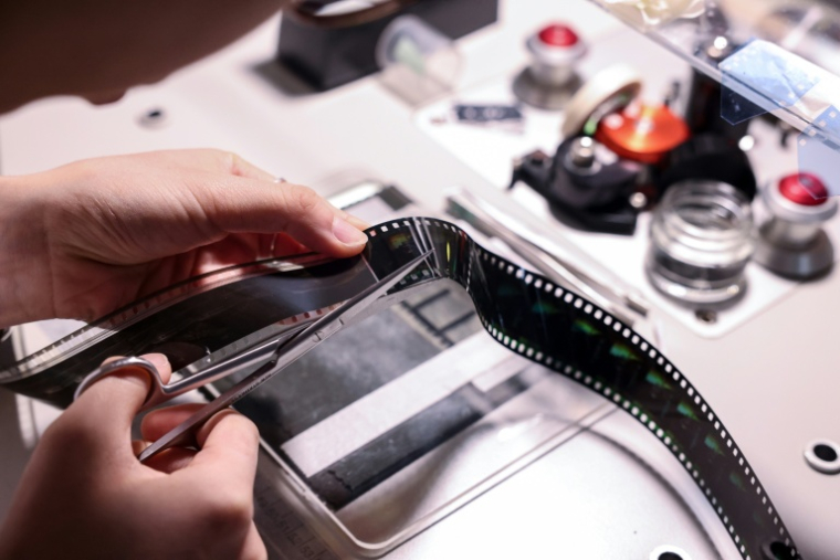 Un technicien répare la pellicule d'un vieux film à l'Institut taïwanais du cinéma et de l'audiovisuel (TFAI), le 23 juin 2026 à Taipeï ( AFP / I-Hwa Cheng )