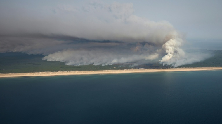 Vue aérienne montrant le panache de fumée de l'incendie au nord du bassin d'Arcachon, le 24 juillet 2026 ( AFP / ROMAIN PERROCHEAU )
