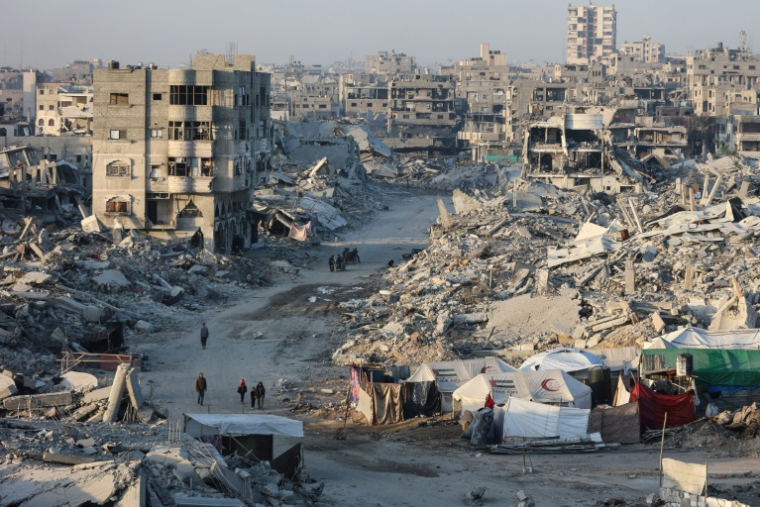 Des Palestiniens marchent dans les ruines de Gaza-Ville le 22 octobre 2025. ( AFP / Omar AL-QATTAA )