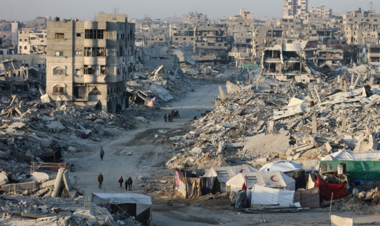 Des personnes marchent au milieu des décombres dans un quartier de la ville de Gaza le 22 octobre 2025 ( AFP / Omar AL-QATTAA )