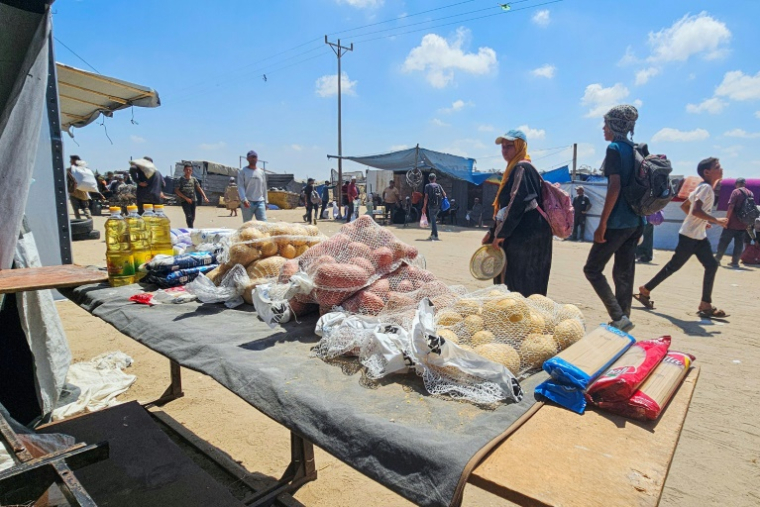 Des Palestiniens regardent des denrées alimentaires sur un étal dans la zone de Mawassi, à Rafah, dans le sud de la bande de Gaza, le 20 juillet 2025 ( AFP / - )