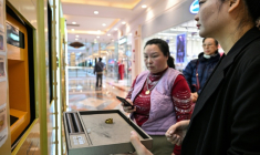 Une employée aide une cliente à vendre un bijou en or dans un automate de Shanghai, en Chine, le 29 janvier 2026 ( AFP / Hector RETAMAL )
