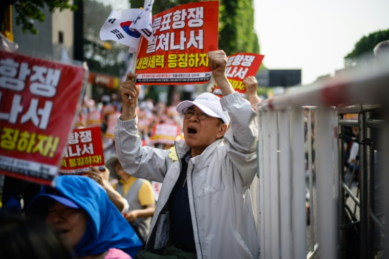 Des manifestants brandissent des pancartes "N'oublions pas l'insurrection du 3 décembre. Punissons les forces insurrectionnelles" lors d'un rassemblement à Seocho, dans le sud de Séoul, le 31 mai 2025, avant l'élection présidentielle du 3 juin en Corée du Sud ( AFP / ANTHONY WALLACE )