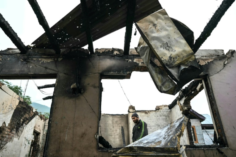 Un Indien inspecte la carcasse de sa maison détruite par l'artillerie pakistanaise dans le village de Salamabad, à 100 km de Srinagar, le 8 mai 2025 ( AFP / Sajjad HUSSAIN )
