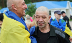 Photo publiée par le quartier général de coordination pour le traitement des prisonniers de guerre, le 20 juin 2025, de prisonniers de guerre ukrainiens enveloppés dans un drapeau national à la suite d'un échange dans un lieu non divulgué en Ukraine ( Quartier général de coordination pour le traitement des prisonniers de guerre / Handout )