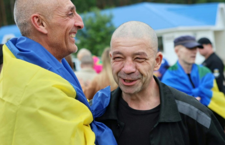 Photo publiée par le quartier général de coordination pour le traitement des prisonniers de guerre, le 20 juin 2025, de prisonniers de guerre ukrainiens enveloppés dans un drapeau national à la suite d'un échange dans un lieu non divulgué en Ukraine ( Quartier général de coordination pour le traitement des prisonniers de guerre / Handout )