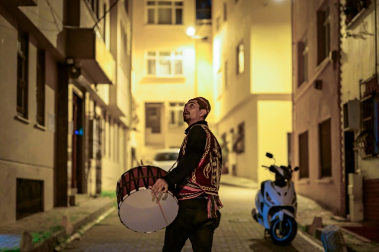 Un joueur de davul, tambour à deux faces, sonne l'heure du dernier repas avant d'entamer le jeûne du ramadan à l'aube, le 24 février 2026 à Istanbul ( AFP / Yasin AKGUL )