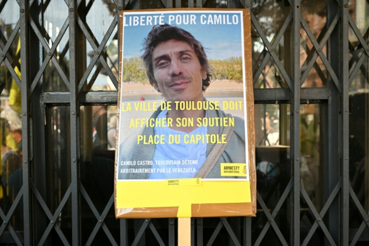 Une photo de Camilo Castro sur une pancarte, lors d'un rassemblement d'Amnesty International et sa famille pour protester contre sa détention au Venezuela, à Toulouse, le 20 septembre 2025 ( AFP / Lionel BONAVENTURE )