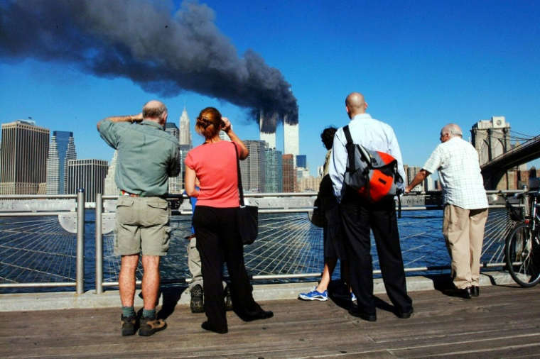 Des piétons regardent les tours du World Trade Center qui ont été heurtées par deux avions de ligne, le 11 septembre 2001 à New York. ( AFP / HENNY RAY ABRAMS )