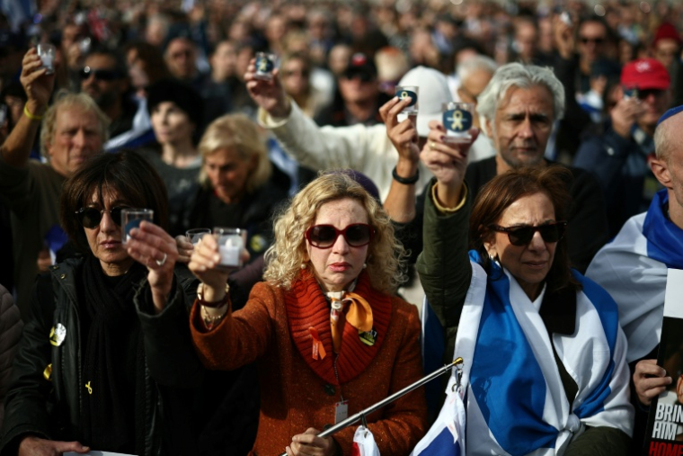 Des personnes tiennent des nougies lors d'une minute de silence à l'occasion d'un événement commémoratif organisé par la communauté juive pour honorer les vies perdues lors de l'attaque du Hamas le 7 octobre 2023, à Londres, le 5 octobre 2025 ( AFP / HENRY NICHOLLS )