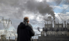 Un homme observe la fumée noire s'échappant de la centrale électrique au charbon d'Afsin-Elbistan, dans la province d'Elbistan, le 11 février 2026 en Turquie ( AFP / Ozan KOSE )