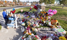 Une femme et un enfant se recueillent devant l’école primaire Silver Rail, après une fusillade, le 17 octobre 2026 à Bend, dans l'Oregon ( AFP / Payton Bruni )