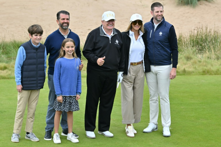 Le président américain Donald Trump pose sur avec ses fils Eric Trump (à droite) et Donald Trump Jr. (à gauche), ainsi que des membres de leur famille, lors de l'inauguration officielle du parcours Trump International Golf Links à Balmedie, dans le nord-est de l'Écosse, le 29 juillet 2025. ( AFP / ANDY BUCHANAN )