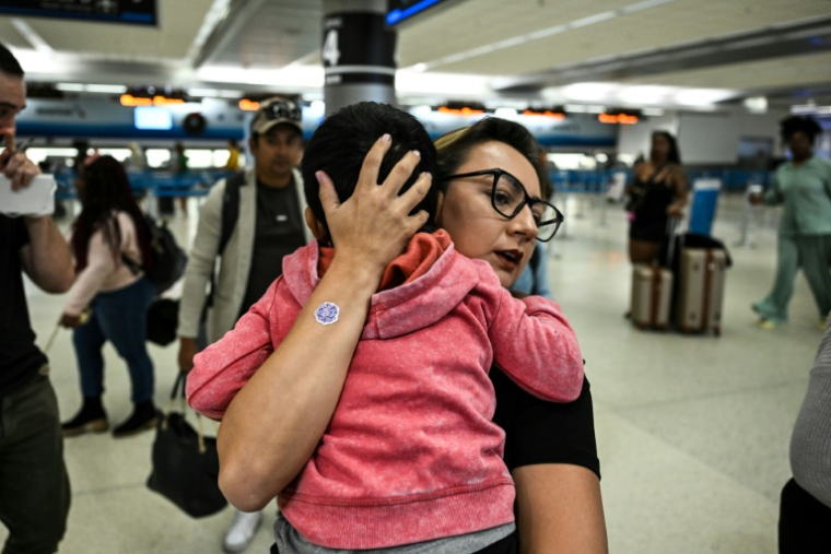 Louisa Gutierrez, du Guatemalan-Maya Center, prend dans ses bras Franklin, 3 ans, à l'aéroport international de Miami, le 4 décembre 2025 ( AFP / CHANDAN KHANNA )