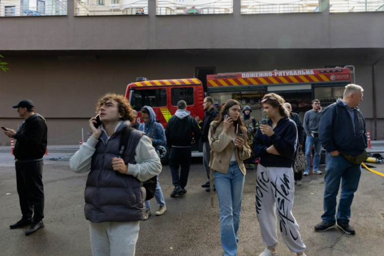 Des habitants observent un immeuble résidentiel endommagé après une frappe de drone russe à Kiev, le 25 septembre 2026 ( AFP / Tetiana DZHAFAROVA )