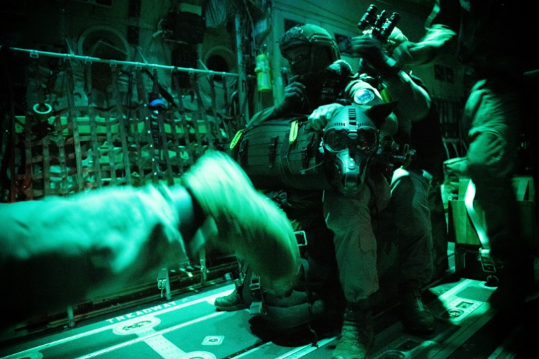 Des membres du GIGN s'apprêtent à sauter en parachute avec un chien policier pour un entraînement près d'Orléans, le 23 juin 2025 ( AFP / JULIEN DE ROSA )